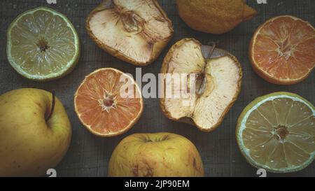 Still life of fruits, lemon, orange and apple, in the process of aging or rusting on a dark wooden table Stock Photo
