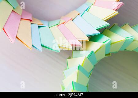 Origami background, rings made of colorful paper sheets, close up photo with selective focus, top view Stock Photo