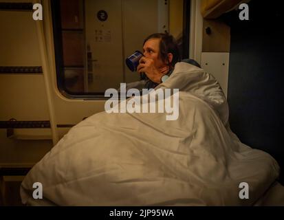 Man before sleeping in compartment of sleeping coach from Prague to Slovakia in summer night Stock Photo
