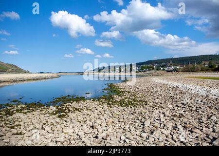 Dried out riverbed of Rhine river nearby the confluence of Nahe and Rhine River at Bingen, Germany - Visible rocks and sandbars due to extraordinary low water level after a long period of drought in August 2022. Stock Photo