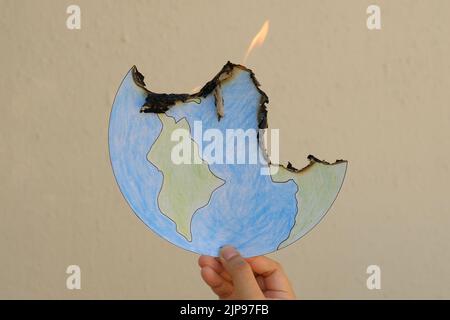 Crayon drawing of the Earth, on fire. The planet is burning, literally from Global Warming, figuratively from hate, greed, racism, terrorism, and wars. Stock Photo