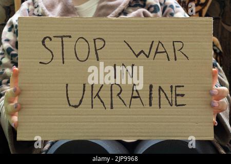 Stop the war in Ukraine written on a sign that a woman holds in her hands from her house in the Dnieper, protest action, martial law in Ukraine Stock Photo