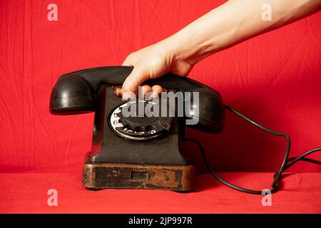 Old retro phone black and woman's hand closeup,call on the phone,technology Stock Photo
