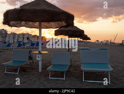 View over empty sunbeds at sandy beach of Rivazzurra, Rimini, Italy on sunset Stock Photo