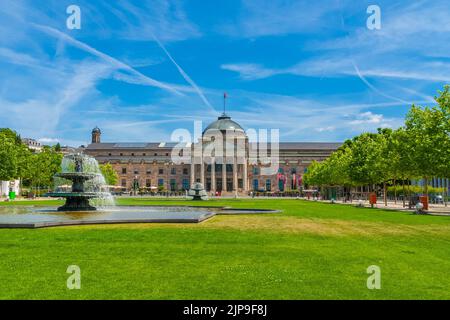 Picturesque view of the main entrance on the west side of Wiesbaden's Kurhaus (spa house) with the so-called Bowling Green, a grass-covered square wit Stock Photo