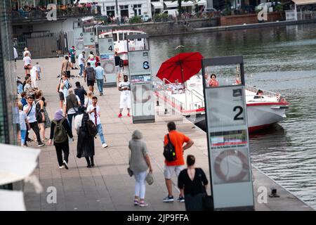 Hamburg, Germany. 16th Aug, 2022. Numerous people stroll in front of the Alster steamers on the Jungfernstieg at the Binnenalster. Credit: Jonas Walzberg/dpa/Alamy Live News