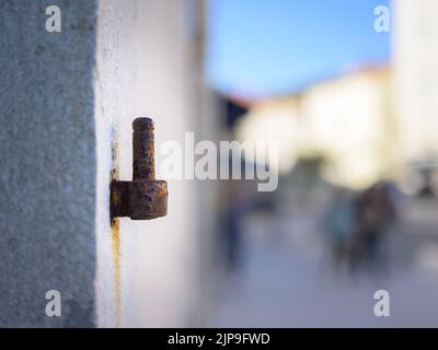 Rusty door hinge on a stone wall outdoors Stock Photo