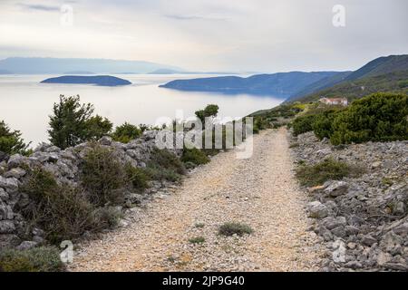 Old road near Predoscica (Cres, Croatia) on a cloudy day in springtime Stock Photo