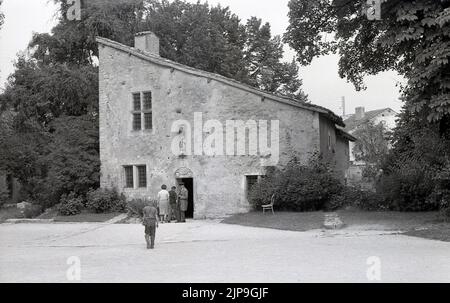 1950s, historical, exterior, La Maison Natale de Jeanne d'Arc, a two-storey stone farm building, with sloping roof, where Joan of Arc was born in the 15th century, Domremy-la-Pucelle, France. A statue stands in front of the house. Her birth house in Domrémy was preserved and became a museum. Also known as the 'The Maid of Orleans' this simple peasant girl is considered a national heroine in French culture, as believing that she was acting under the will of god, she led the French army to victory at Orleans in 1429 against the English during the Hundred Years War. Stock Photo