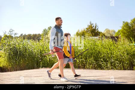 happy smiling father and son fishing on river Stock Photo