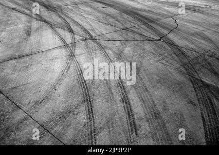 Black tire tracks or marks from driving on cement drive Stock Photo