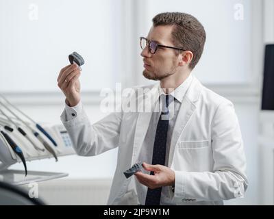 Dentist looking at photopolymer jaw printed on a 3d printer. Stock Photo