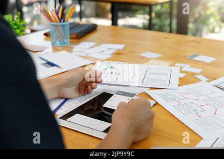 UX UI Concept, Graphic designers work together with UX UI designer planning application template layout framework for mobile phone computer mobile Stock Photo