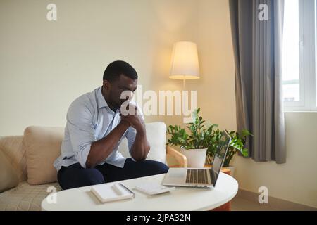 Pensive Black man watching video on managing personal finances Stock Photo