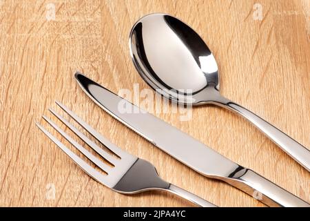 Fork, knife, spoon on wooden table. Cutlery set Stock Photo