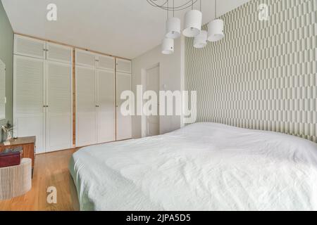 Interior of contemporary bedroom with white walls and open bathroom in attic of house Stock Photo
