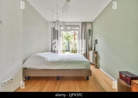 Interior of contemporary bedroom with white walls and open bathroom in attic of house Stock Photo