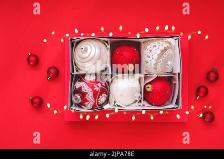 Christmas filled box with red and white Christmas decoration on red background. Top view, place for text Stock Photo