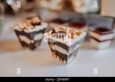 stylish desserts with strawberry, candy bar with sweets at luxury wedding reception. catering at restaurant. cupcakes macaroons on table. space for Stock Photo