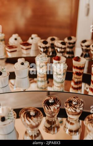 stylish desserts with strawberry, candy bar with sweets at luxury wedding reception. catering at restaurant. cupcakes macaroons on table. space for Stock Photo
