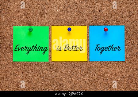 Three colored paper notes on corkboard with words Everything is Better Together. Close-up Stock Photo