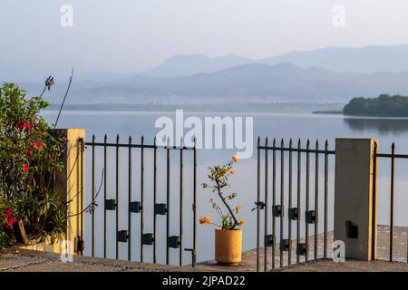 A beautiful view of Laguna de Coyuca (Coyuca lagoon) from the resort town Pie de la Cuesta north of Acapulco, Guerrero, Mexico. With gate and flowers. Stock Photo