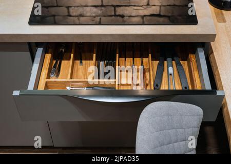 Modern kitchen. Set of cutlery trays in kitchen drawer. Solid oak wood cutlery drawer inserts. Stock Photo