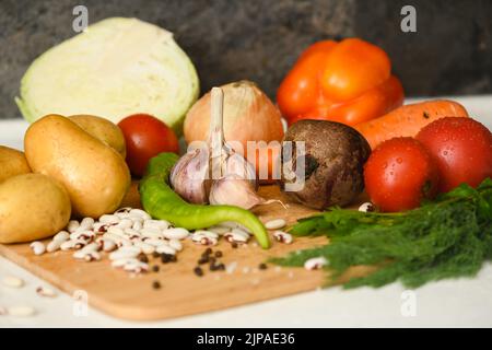 Ingredients for cooking the national Ukrainian dish - borscht. Fresh vegetables are arranged on a wooden cutting board. Preparing to cook borscht. Stock Photo