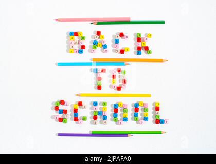 Back To School words made of number beads and underlined with colourful pencils. Stock Photo