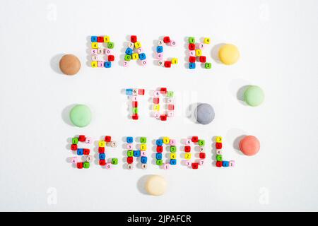 Colourful number beads in words Back To School and Macarons cookies on white background. Stock Photo
