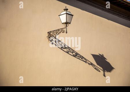 Electric old fashioned lamp light mounted on historic facade. Stock Photo
