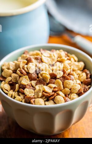 Breakfast cereal flakes in a bowl on wooden table. Stock Photo