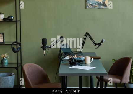 Background image of podcast workstation in muted green tones with focus on pro microphones and equipment, copy space Stock Photo