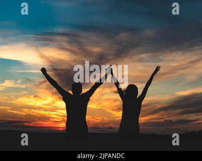 couple with arms raised Stock Photo