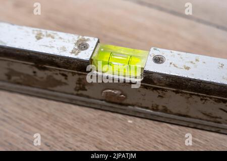 used bubble construction level lying on a ceramic tile floor  Stock Photo