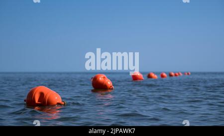 Orange floating buoys in the sea. Human life saving concept. Blue sky. Stock Photo