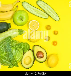 Creative layout of green and yellow fruits and vegetables on yellow background. Antioxidant and healthy lifestyle concept. Flat lay Stock Photo