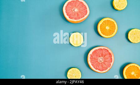 Summer creative oranges, lemons and grapefruits pattern with copy space on bluebackground. Tropic citrus fruits concept. Flat lay Stock Photo