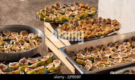 Various figs are lying on various flat bowls to dry in the sun Stock Photo