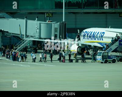 Line of passengers queuing to board summer holiday flight, Stansted Airport, Essex, England, United KIngdom Stock Photo