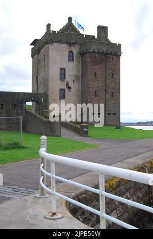 Broughty Castle, with white railings in foreground and saltire flag flying, sits at the mouth of the Tay Estuary at Broughty Ferry, near Dundee. Stock Photo