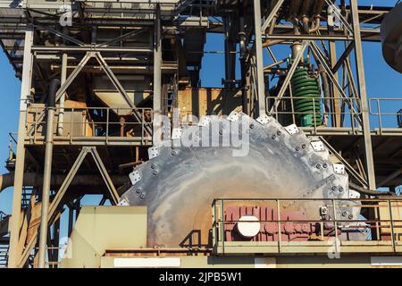 Close-up detail part of heavy metal construction of open pit gravel plant sand quarry big rusty rotor machine material excavating and crushing Stock Photo