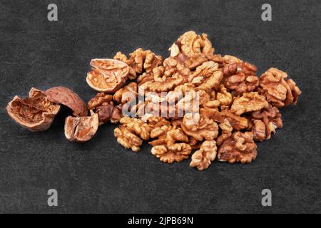 Pile of walnuts on a stone black surface Stock Photo