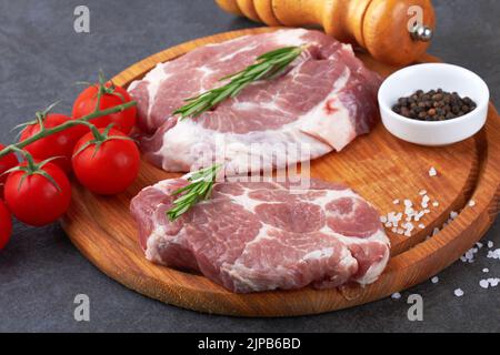 Raw meat with tomatoes on a black surface Stock Photo