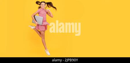 happy child girl hurry up running hold notebook to find sale and discount, energy. School girl portrait with laptop, horizontal poster. Banner header Stock Photo