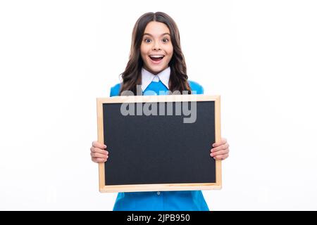 Teenager younf school girl holding school empty blackboard isolated on white background. Portrait of a teen female student. Stock Photo