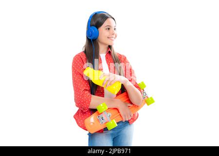 Teenagers youth casual culture. Teen girl with skateboard over isolated studio background. Teenager in fashion stylish clothes. Stock Photo