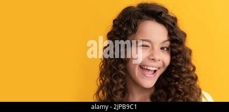 happy winking teen girl with long curly hair and perfect skin, frizzy. Child face, horizontal poster, teenager girl isolated portrait, banner with Stock Photo