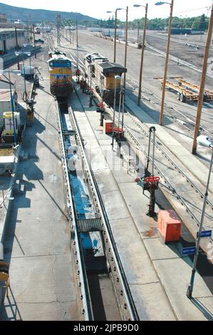 Railroad train yard with sidings and switchers and engines and cars and repair facilities in Utah Stock Photo