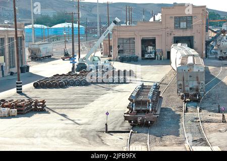 Railroad train yard with sidings and switchers and engines and cars and repair facilities in Utah Stock Photo